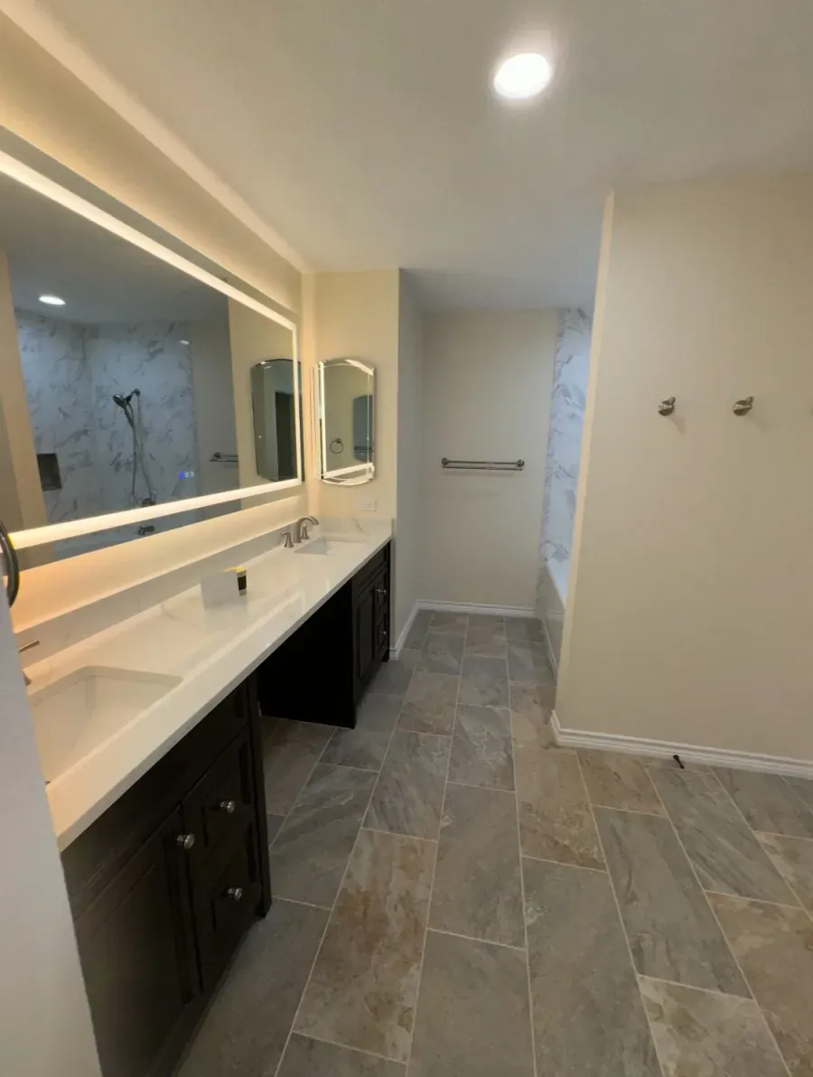 Double vanity with LED backlit mirror and large format tile flooring — bathroom remodel in San Antonio, TX